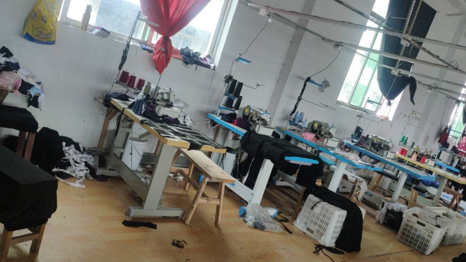 Industrial sewing stations and steam ironing area on the factory production floor
