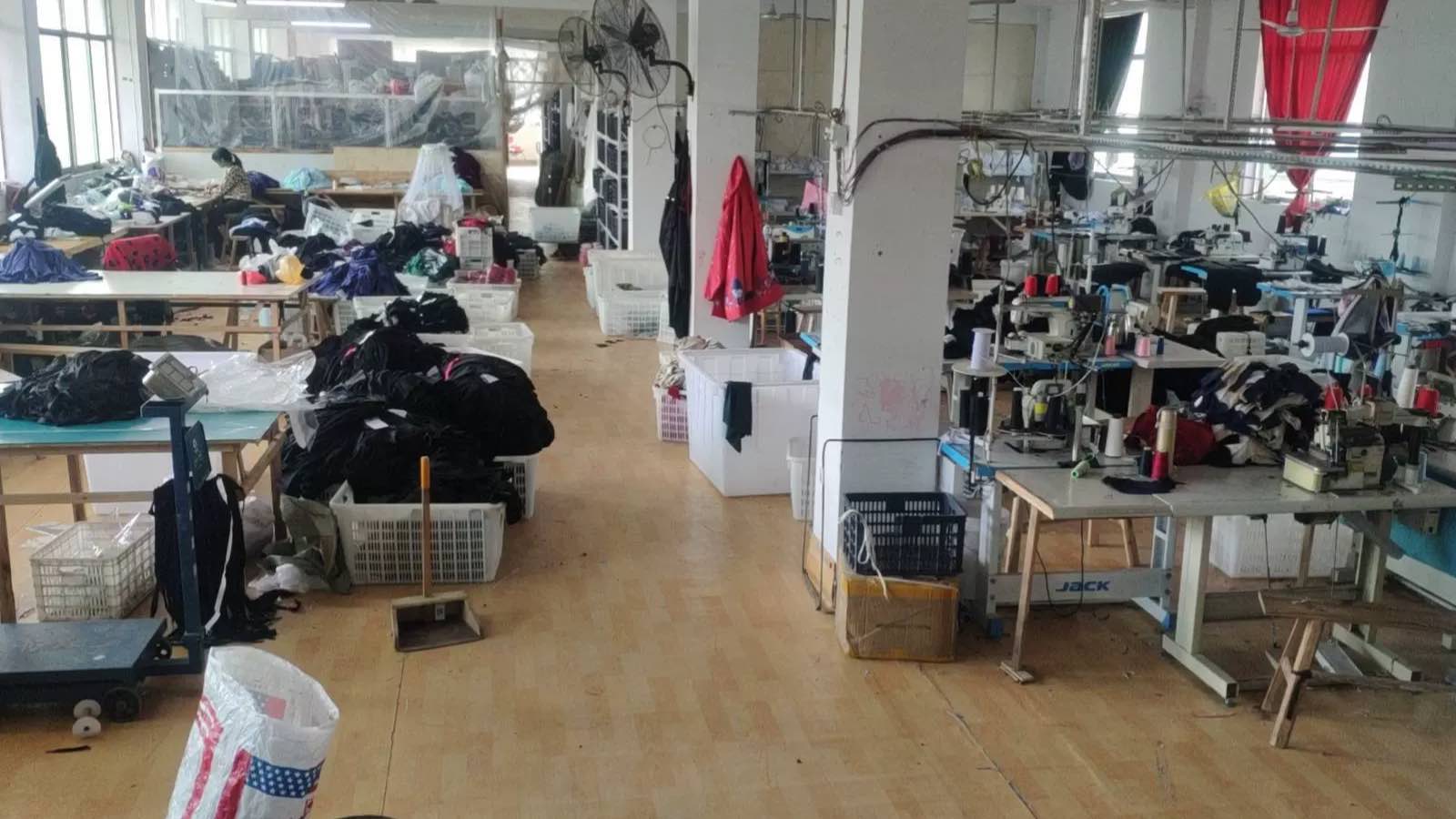 Overview of the garment factory floor with rows of industrial JACK sewing machines and work in progress